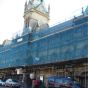 Blue debris netting installed on scaffold face of urban construction site corporate branding application | CMT Group UK