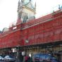 Red debris netting installed on scaffold face of construction site danger zone perimeter application | CMT Group UK