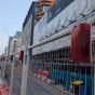 Battery powered red LED hoarding lights fitted along temporary site fencing urban construction site London | CMT Group UK