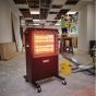 110V infrared cabinet heater in use on construction site showing radiant heat from twin halogen elements | CMT Group UK