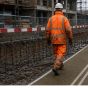 Mobi-Mat heavy duty walkway mat unrolled over muddy construction site operative walking on mat | CMT Group UK