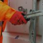 Smooth nitrile grip gloves worn in use on site operative opening metal container latch | CMT Group UK