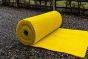 Yellow Anti-Slip Spaghetti Site Mat - 12mm x 1m x 10m Roll shown as a rolled mat on outdoor gravel surface | CMT Group